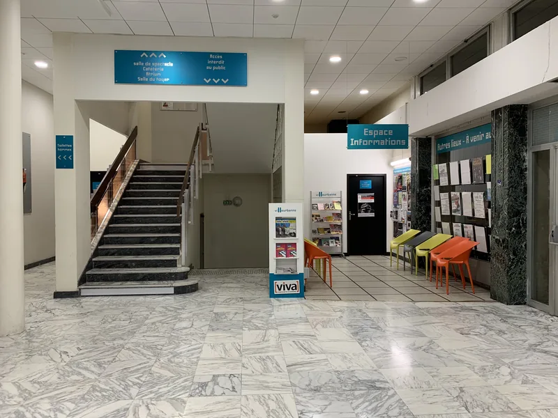 Le hall en marbre du CCVA de Villeurbanne, avec l'escalier, le panneau Espace Informations et un mur d'affiches