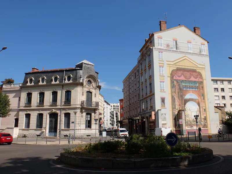 Fresque en trompe-l'œil peinte sur un mur pignon aux Charpennes, face à un rond-point planté